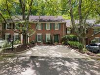 Charming brick townhome featuring a driveway and surrounded by mature trees at 1355 E Rock Springs Ne Rd, Atlanta, GA 30306