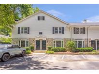 Charming two-story townhome with stone accents, well-maintained landscaping, and parking space at 136 Peachtree Memorial Nw Dr # 8-2, Atlanta, GA 30309