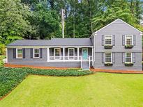 Charming two-story home with a landscaped yard, gray siding, and flower boxes under the windows at 261 Lamplighter Se Ln, Marietta, GA 30067