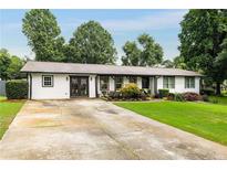 Charming home featuring a well-manicured lawn, a long driveway, and lovely landscaping at 3844 Sw Saddle Ridge Dr, Snellville, GA 30039