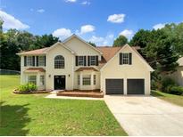 Charming two-story home featuring a well-manicured lawn and an attached two-car garage at 5159 Round Table Dr, Ellenwood, GA 30294
