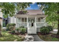 Charming home with a covered front porch, white railings, and well-manicured landscaping at 658 Mcgruder Ne St, Atlanta, GA 30312