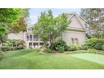 Beautiful backyard with an artificial grass lawn, lush landscaping, putting green, and a screened-in porch at 15 Northwood Ne Ave, Atlanta, GA 30309
