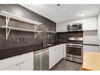 Modern kitchen features stainless steel appliances, stone countertops, and open shelving at 1501 Clairmont Rd # 1522, Decatur, GA 30033