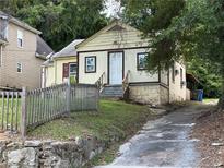 Charming single-Gathering home featuring a quaint design, stone foundation, and a welcoming front entrance at 2009 Baker Nw Rd, Atlanta, GA 30318