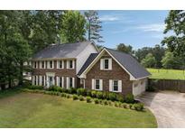 Beautiful two-story brick home with manicured lawn and mature trees at 4188 Kindlewood Ne Ct, Roswell, GA 30075