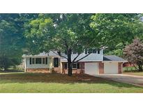Charming home with brick accents, complemented by lush trees and a well-manicured lawn at 1102 Tony Valley Dr, Conyers, GA 30013