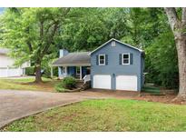 Charming split-level home with blue siding, a two-car garage, and a welcoming front yard at 4990 Turtle Rock Drive Dr, Marietta, GA 30066