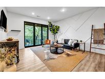 Bright living room features a modern design, sleek furniture, balcony access, and abundant natural light at 112 Rogers Street Ne # 503, Atlanta, GA 30317
