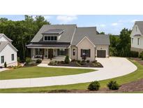 Stunning exterior view featuring a two-story home, well-manicured lawn and beautiful, winding concrete driveway at 4445 Pebble Rock Dr, Cumming, GA 30041