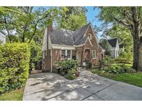 Charming brick home with a well-maintained lawn, mature trees, and a long driveway at 1718 Ridgewood Ne Dr, Atlanta, GA 30307