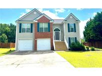 Charming two-story home featuring a two-car garage, brick accents, and a well-manicured front lawn at 203 Galway Ln, Hampton, GA 30228