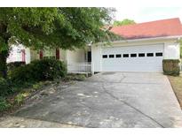 Charming single-Gathering home featuring a two-car garage, well-kept lawn, and a red roof at 3041 Regal Dr, Mcdonough, GA 30253