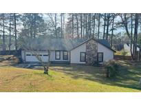 Charming single-story home featuring stone accents, attached garage, and a well-maintained front lawn at 5359 Stafford Nw Dr, Lilburn, GA 30047
