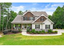 Charming home featuring stone accents, a cozy front porch, and a well-manicured lawn and landscaped garden at 510 Black Horse Cir, Canton, GA 30114