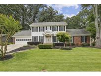 Charming two-story home featuring a well-manicured lawn, classic shutters, and an attached two car garage at 4624 Stonehenge Dr, Atlanta, GA 30360