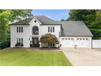 Elegant two-story home featuring a well-manicured lawn and three-car garage at 5286 Wild Indigo Nw Way, Acworth, GA 30102