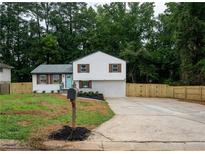 Charming two-story home featuring a bright blue front door, fresh landscaping, and a newly paved driveway at 6050 Randy Ln, Ellenwood, GA 30294