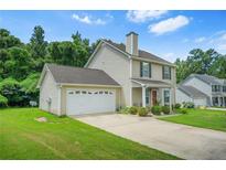 Charming two-story home with attached garage, well-maintained lawn and driveway on a sunny day at 30 Creek Bottom Dr, Covington, GA 30014