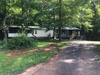 Charming single-story home featuring a covered porch and surrounded by mature trees for added privacy at 4744 Chickasaw Se Way, Acworth, GA 30102