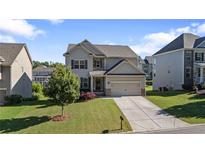 Charming two-story home with stone accents, well-manicured lawn, and an attached two-car garage at 2050 Poplar Ridge Pl, Cumming, GA 30040