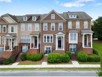Charming townhome exterior featuring brick accents, manicured landscaping, and inviting entrances at 2367 Millhaven Se St, Smyrna, GA 30080