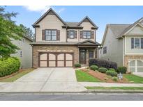 Charming two-story home featuring a stone-accented front, landscaped yard, and a two-car garage at 132 Cornerstone Pl, Woodstock, GA 30188