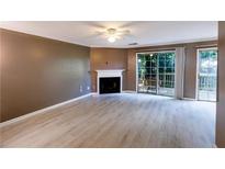 Spacious living room featuring a fireplace, and access to the outdoor patio at 3396 Misty Harbour Trl, Doraville, GA 30340