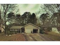 Charming single-story home with a two-car garage and mature trees surrounding the property at 791 Bristol Way, Lithonia, GA 30058