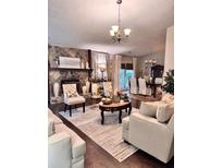 Comfortable living room with stone fireplace and elegant chandelier creating a warm and inviting atmosphere at 791 Bristol Way, Lithonia, GA 30058
