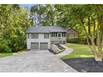 Charming split-level home featuring a two-car garage, screened porch entry, and mature trees at 3902 Robin Court Ct, Acworth, GA 30101