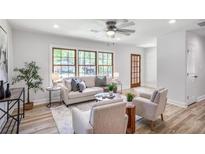 Bright living room features large windows, light colored walls, and wood-look floors at 911 Oakland Sw Dr, Atlanta, GA 30310