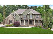 Charming two-story home with a covered porch and well-manicured lawn at 511 Millwood Ct, Canton, GA 30114