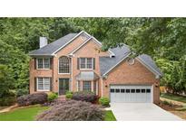Charming brick home with well-maintained landscaping and attached two-car garage at 878 Treadstone Overlook, Suwanee, GA 30024