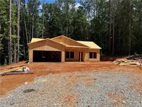 Unfinished home with wooden framework, on a large lot surrounded by trees at 1100 Pleasant Grove Church Rd, Villa Rica, GA 30180
