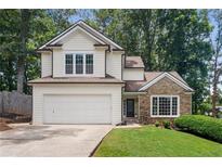 Charming home featuring a two-car garage, stone accents, and lush landscaping at 4816 Morning Chase Nw, Acworth, GA 30102
