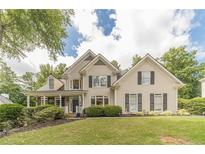 Charming two-story home with manicured lawn, mature trees, and classic architectural details at 1461 Radstone Dr, Lawrenceville, GA 30044