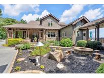 Beautiful home featuring a stone fire pit and lush landscaping at 52 Waterside Se Dr, Cartersville, GA 30121