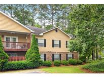 Charming two-story townhouse with a balcony, and stone accents, nestled in a lush, green landscape at 106 Brighton Pt, Sandy Springs, GA 30328