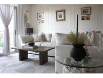 Bright living room features neutral décor, plush sofa, and large windows with sheer curtains at 711 Cosmopolitan Dr # 413, Atlanta, GA 30324