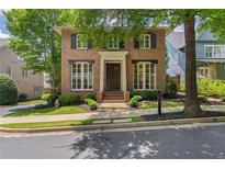 Charming brick home featuring a symmetrical facade, manicured landscaping, and a welcoming front entrance at 175 Centennial Trce, Roswell, GA 30076