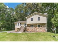 Charming home with a stone accent facade and wooden stairs leading to the front door at 2645 Holly Berry Trl, Snellville, GA 30039