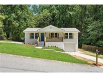 Charming white brick home with a welcoming front porch and well-manicured lawn at 3013 Michael Sw Dr, Marietta, GA 30060