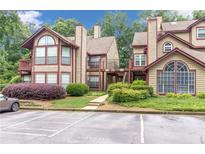 Condominium complex featuring two-story buildings, well-maintained landscaping, and convenient parking spaces at 404 Hawkstone Way, Alpharetta, GA 30022