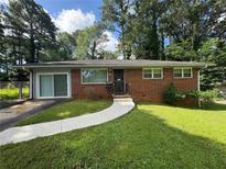 Charming brick home featuring a well-manicured lawn and a curved walkway leading to the front door at 2651 Bull Run Dr, Decatur, GA 30034