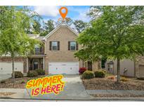 Charming brick townhome with a two-car garage and well-manicured landscaping at 2860 Cooper Brook Dr, Snellville, GA 30078