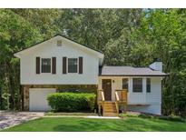 Charming two-story home with white siding, stone accents, and a well-manicured front yard at 4030 Tanglewood Rd, Snellville, GA 30039