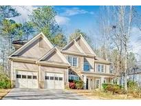 Charming two-story home with a three-car garage and stone detailing on the exterior at 380 Victorian Ln, Duluth, GA 30097