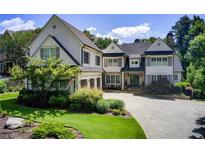 Beautiful two-story home featuring a stone chimney, well-manicured lawn and an attached three-car garage at 4559 Paradise Shoals Se Rd, Atlanta, GA 30339
