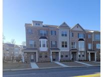 Charming townhome exteriors with brick facade, covered entries, and well-manicured lawns offer appealing curb appeal at 547 Fundao Ln # 24, Lawrenceville, GA 30046